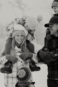 black and white family smiling at each other in winter