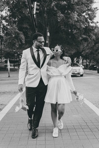 bride and groom walking on a cross walk with their arms around each other
