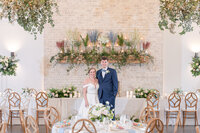 Bride and groom in front of flowers