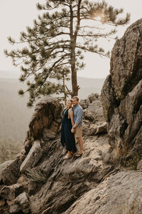 couple standing on rocks on top of a gultch in Colorado