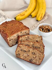 A loaf of sliced gluten-free banana bread with walnuts.