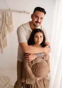 Family portrait session in Fort Worth featuring parents and two daughters in a light-filled studio with natural poses

