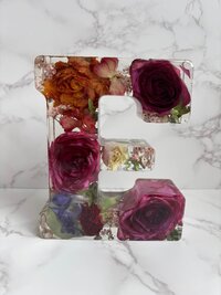 A letter block of the letter E with preserved bridal flowers.