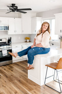 Photographer Megan Williamson sitting on top of a kitchen counter