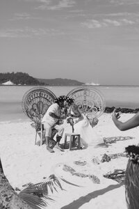 A tropical wedding in French Polynesia, featuring a barefoot bride walking down a floral-lined aisle on the soft white sands of Bora Bora.