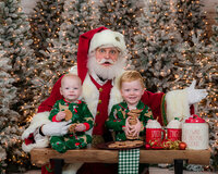 Santa with two young boys in matching PJs
