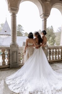 Zwei Bräute stehen mit dem Rücken zur Kamera in Brautkleidern