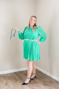 Becca playfully holding a stethoscope in one hand.