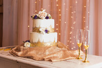 wedding cake flowers on a gold rimmed wedding cake
