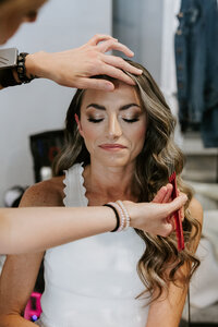 Close up of hairstylist putting finishing detail touches on her brides hair