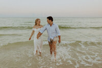 newlyweds on beach in front of pier