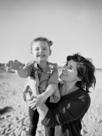Black and white photo of a mom and her daughter on the beach