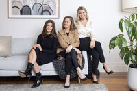 Portrait of three female work team members sitting on a couch