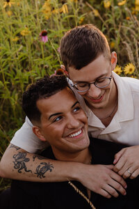 A couple sitting with their arms around each other smiling