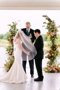 A beautifully decorated floral wedding ceremony, featuring vibrant blooms and elegant arrangements, set in a serene outdoor venue.