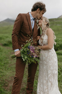 A couple holding a bouquet of wildflowers.