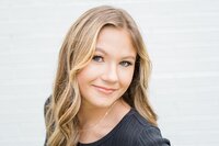 Headshot of blond girl against white brick wall in Glasgow, KY