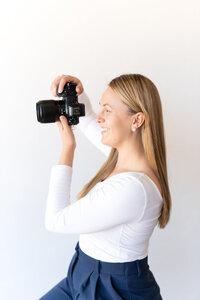 Whitney Marshall Photo holding black camera up to take a picture