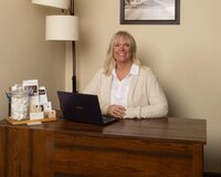 Brook Pederson sitting in her massage therapy office smiling