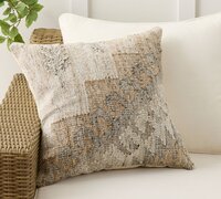 Neutral tone kilim pillow on a couch. 