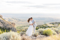 Bride and groom sharing a romantic kiss on their wedding day at Five Springs Campground in Lovell, Wyoming, with breathtaking mountain views as their backdrop.