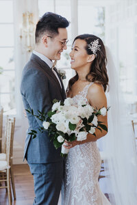 Wedding Photographer, bride and groom gaze at each other, she holds her bouquet