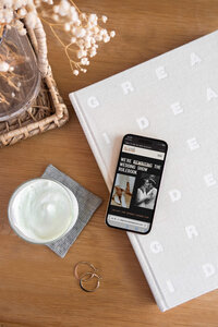 An iphone displays an example of a showit website design for a weddding expo. 