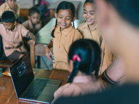 kids hanging out around a computer and smiling