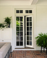 Boston interior designer transforms a historic home's outdoor living space with a covered porch, modern furniture, and original brick pavers for timeless style.