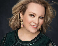 Close-up beauty portrait of a smiling blonde woman with statement earrings and a green embroidered top, photographed by The Picture House in Birmingham, Alabama.