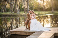 Couple poses during their wedding photos by the lake at this outdoor wedding venue in Orlando.