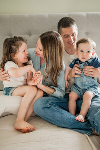 Family of four interacting on the master bed during pictures with San Antonio photographer Cassey Golden