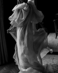 Black and white image of bride wearing Monique Lhuillier bridal gown with sheer fashion cape in Raffles London