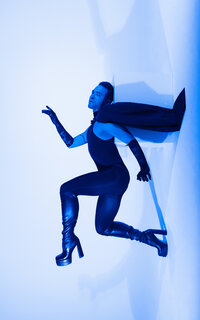 Blue-toned editorial image of person seated with hand gesture – symbolic branding image from Mewphotovideo’s Studio Lab