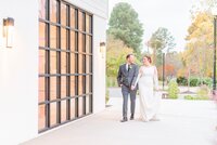 A couple walks hand in hand in front of the Distillery.