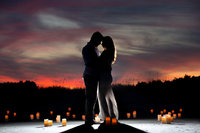 Couple poses for a silhouette beach portrait with candles at Huntington Beach State Park