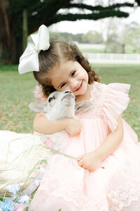 Girl hugging lamb smiling at the camera
