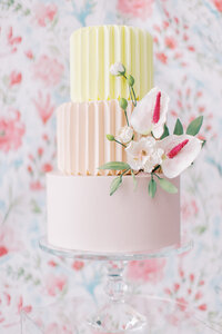 close up detail shot of a wedding cake  and floral background at a Alberta wedding photographed by calgary wedding photographers Heidrich Photography