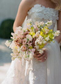 Bridal bouquet of white garden roses, peonies, ranunculus, sweet peas, scabiosa, butterfly ranunculus and dark greenery in floral hues of white, cream, and blush. Designed by Rosemary and Finch in Nashville, TN.