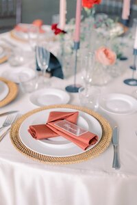 Reception dining with pink napkins on white table cloth