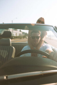 Nostalgic film photography of couple in a convertible