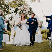 Coppia di giovani sposi cammina durante il lancio dei petali dopo la cerimonia civile, presso Tunuta Quadrifoglio.