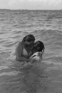 A newlywed couple takes a joyful leap into the crystal-clear turquoise waters of Bora Bora, celebrating their luxury destination wedding with a spontaneous ocean jump.