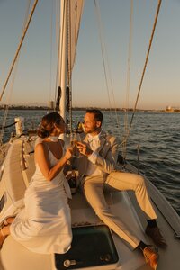 bride and groom lean in for kiss on sail boat