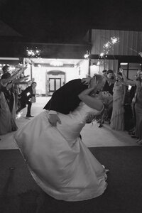 groom dips bride at their wedding exit