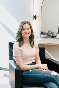 Kim, stylist at Lavender & Ink Studios, seated at styling station