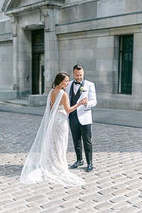 Un couple de nouveaux mariés dans une rue du Vieux Montréal. Ils sont élégants. Mariage Vieux-Montréal. Mariage sophistiqué.