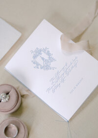 A closeup of a wedding invitation with a ribbon