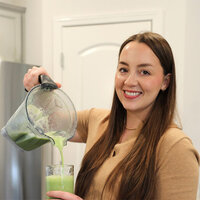 Lauren Marshall pours a green smoothie from a blender, showcasing her healthy beverage preparation.