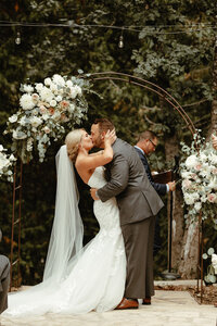 bride and groom kissing at the alter